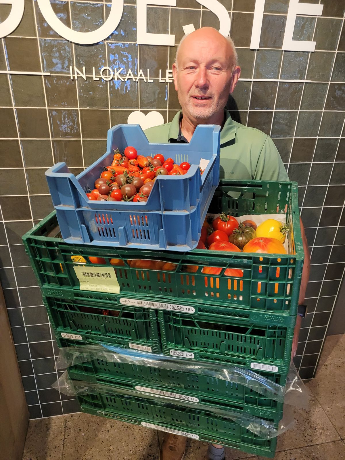Bernard met bakken vol tomaten uit de Goestuin