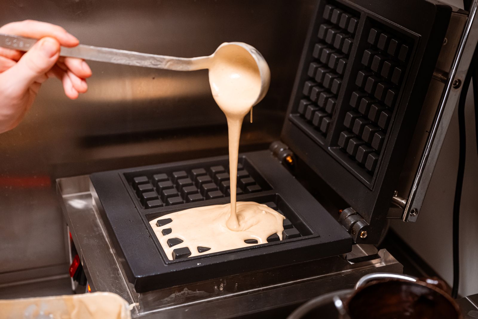 Huisgemaakt wafelbeslag gaat in het wafelijzer